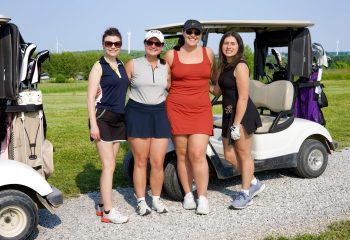 Four women golfers posing by a golf cart during Women’s Golf Day at Ironwood Golf Course in Western New York